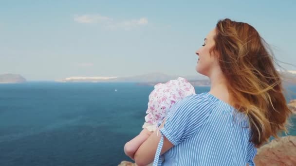 Vacker ung mamma kyss dotter vid havet solnedgång och strand bakgrund. Lycklig familjesemester. Kaukasiska lycklig hona med baby utanför på Ocean Sunset. Moderskapet kärlek vård. — Stockvideo