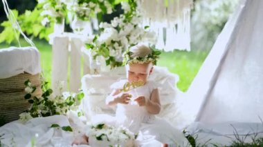 Beyaz elbiseli bir kız wigvam yakınlarındaki doğum günü partisinde kelime bir ile isim plakası alır. 4k