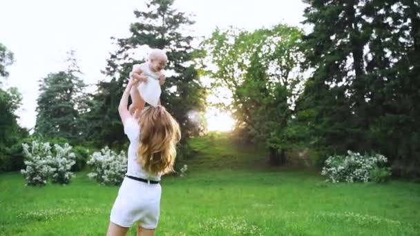 Une jeune femme jette le bébé dans le parc — Video