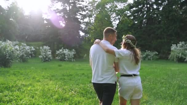 A young couple with a little daughter walks in the park. Happy family vacation. c — Stock Video