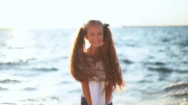 Genç kız deniz kenarında ayakta başını kaldırdı