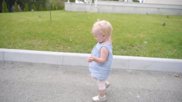 Niña pequeña caminando en ropa casual al aire libre — Vídeos de Stock