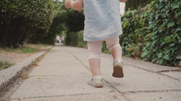Malá holčička, která chodí po městské ulici — Stock video