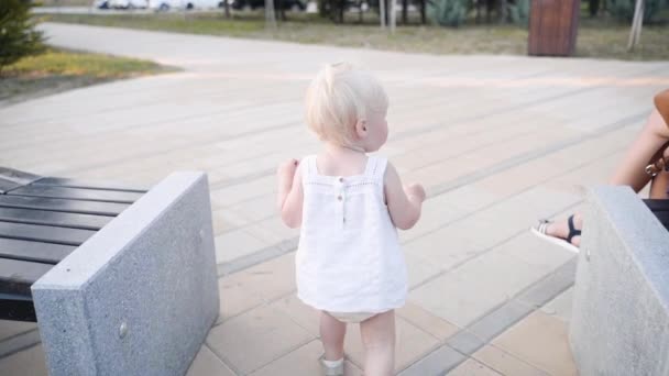 Kleine peuter in witte jurk wandelen buiten — Stockvideo