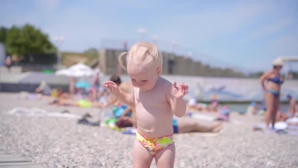 Niña pequeña caminando en la playa de la ciudad — Vídeos de Stock