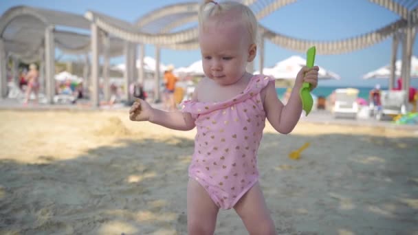 Menina criança pequena brincando na praia da cidade — Vídeo de Stock