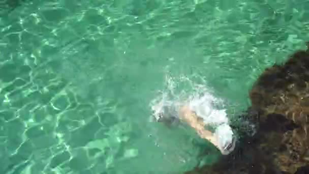 Ung vuxen kvinna i baddräkt hoppar i kristallvatten — Stockvideo