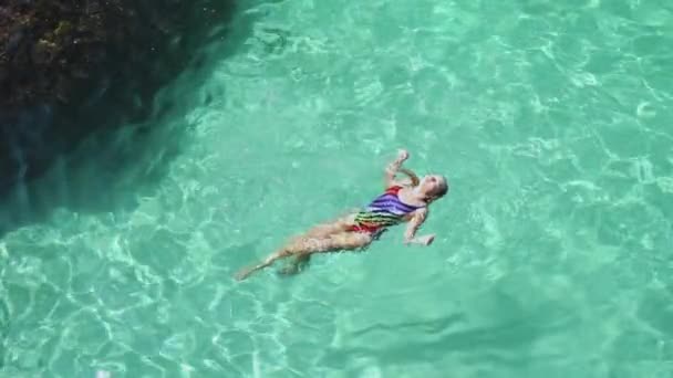在清澈海水中游泳的年轻成年女子 — 图库视频影像