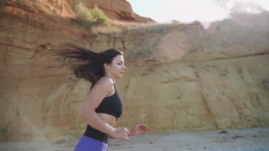 Sportif vücutlu genç bir kadın dışarıda antrenman yapıyor.