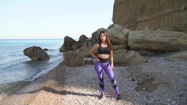 젊은 운동 선수인 여성의 포즈를 취하고 야외에 서 있다 — 비디오