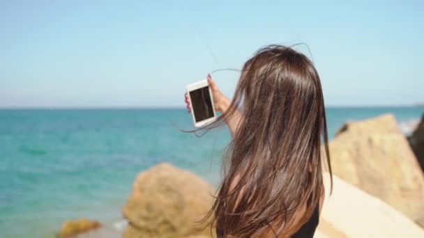 Jonge volwassen vrouw met behulp van moderne smartphone, het maken van selfie. Langzame beweging — Stockvideo