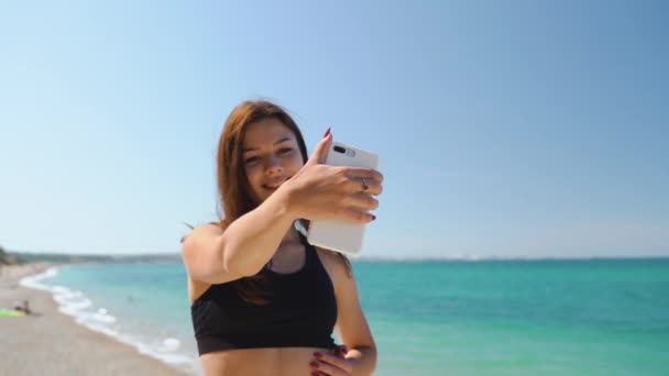 Молодая женщина делает автопортрет на смартфоне — стоковое видео
