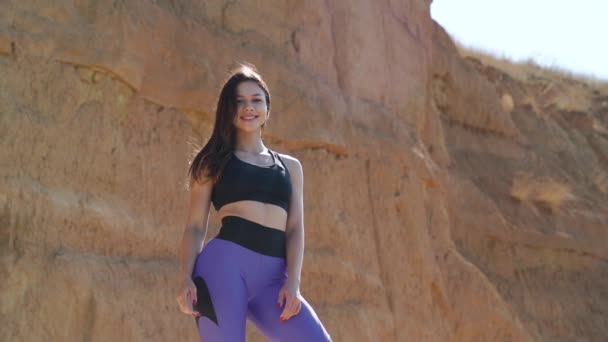 Joven mujer deportiva adulta sonriendo y posando en ropa deportiva outdoot — Vídeo de stock