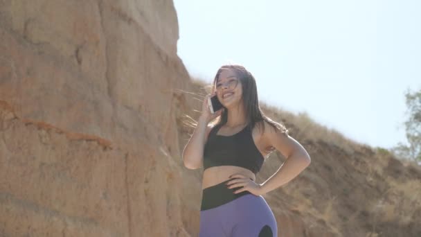 Mujer joven adulta con teléfono inteligente moderno hablando al aire libre — Vídeo de stock