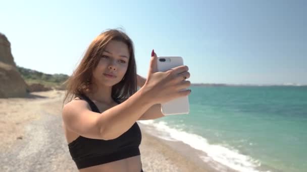 Chica joven adulta haciendo auto foto en un teléfono inteligente moderno — Vídeos de Stock