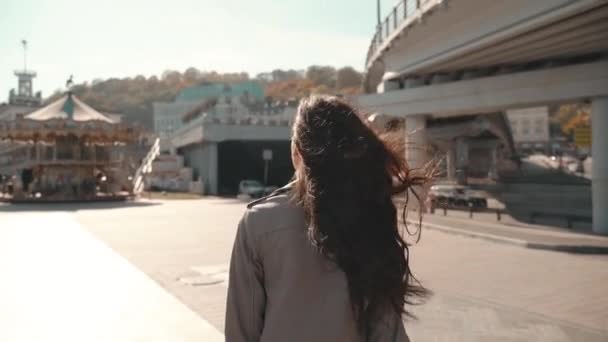 Молодая взрослая женщина, идущая на городской площади — стоковое видео