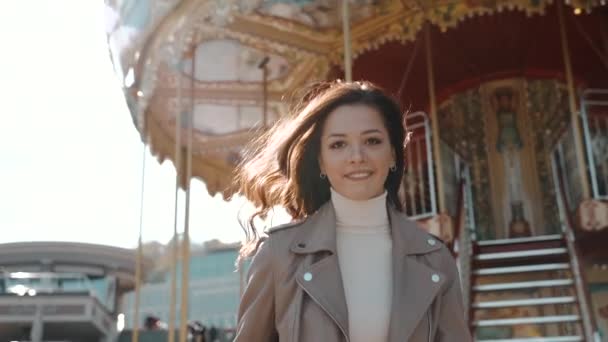 Young adult lady walking near carousel and smiling wide — Stock Video