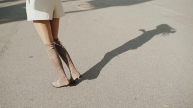 Genç yetişkin insan asfalt yolda gölge düşürüyor.