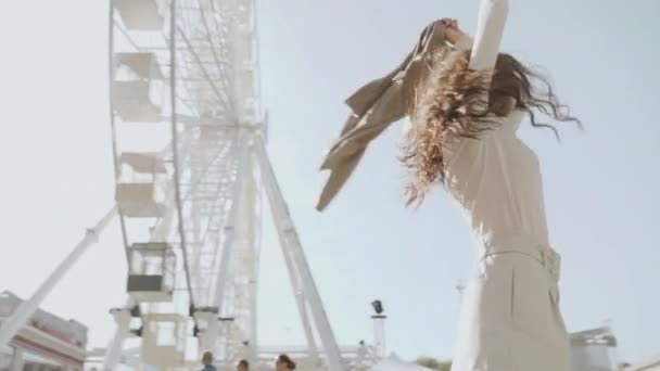 Young adult woman spending sunny day near ferris wheel — Stock Video