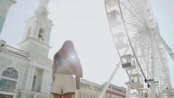 Mladá dospělá dáma chůze v blízkosti zábavního parku s ruským kolem — Stock video