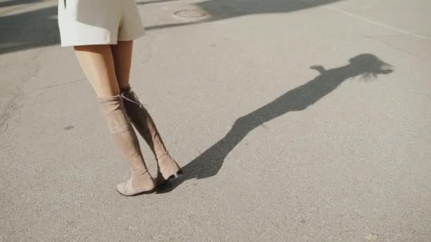 Fiatal felnőtt személy árnyékot vet az aszfaltozott útra — Stock videók
