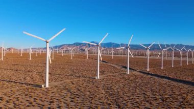 Geleceğin insansız hava aracı görüntüleri, Palm Springs yakınlarındaki Kaliforniya çölünde geniş bir rüzgar enerjisi çiftliği olduğunu gösteriyor. Pürüzsüz kamera hareketi beyaz türbinlerin simetrik sıralarını yakalar