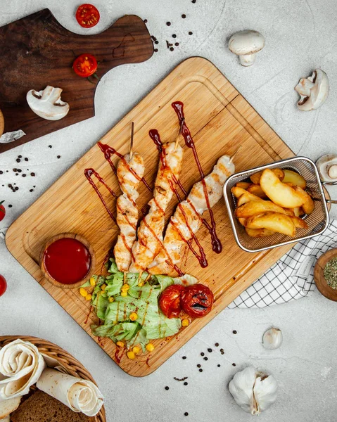 Bâtonnets de poulet rôtis avec pommes de terre frites — Photo