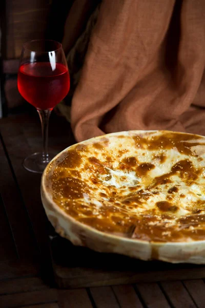 Піца з келихом червоного вина на столі — стокове фото