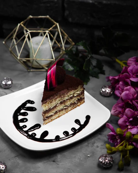 Stück Kuchen serviert mit Deko-Schokolade auf dem Teller — Stockfoto