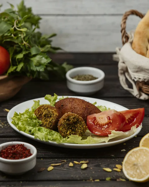 Turkish kibbeh diisi bakso daging disajikan dengan tomat, dan selada — Stok Foto