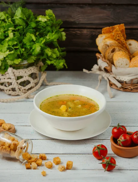 Un tazón de sopa de pollo con patata, zanahoria y eneldo servido con rebanadas de pan —  Fotos de Stock