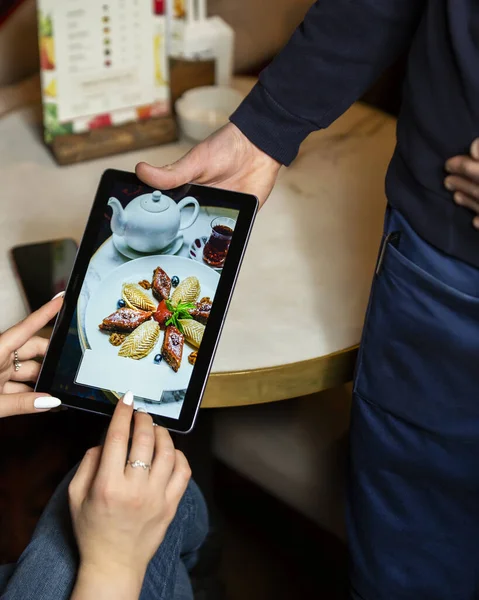 Kelner wyświetla klientowi menu deserowe na tablecie w restauracji — Zdjęcie stockowe