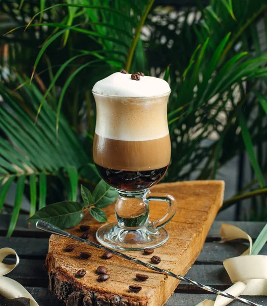 Καφέ στρωμένος με κρέμα γάλακτος και κόκκους καφέ σε ξύλο ρουστίκ — Φωτογραφία Αρχείου