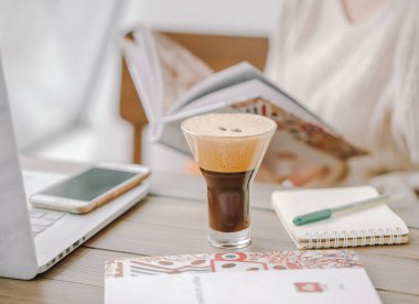 köpüklü naneli mocha, üzerinde kahve çekirdekleri ve defter.