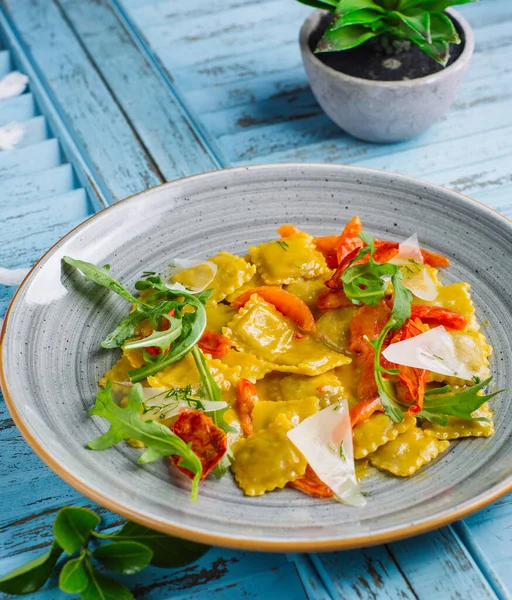 Spinat und Ricotto Ravioli mit Parmesan, getrockneten Tomaten, Rucola — Stockfoto