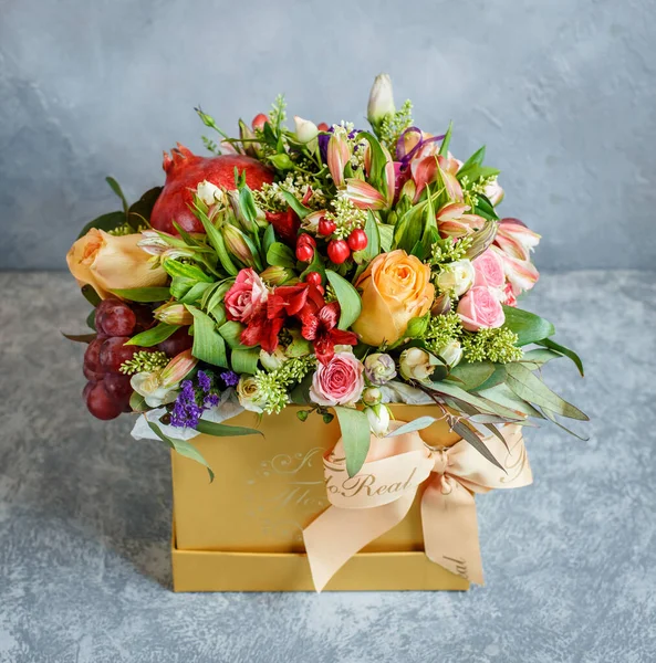 Egy gyönyörű virágcsokor gránátalmával és szőlő sárga doboz csokornyakkendővel — Stock Fotó