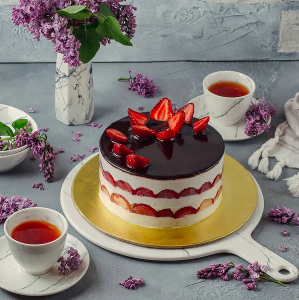 Choklad täckt jordgubbstårta serveras med te — Stockfoto