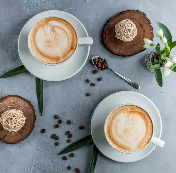 Pemandangan atas dari dua cangkir cappuccino dalam cangkir putih dengan latar belakang abu-abu — Stok Foto