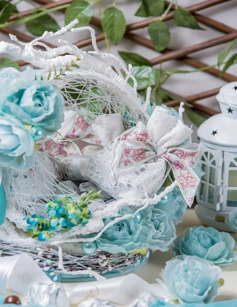 Cesta de sacos de chocolate decorados com flores artificiais azuis — Fotografia de Stock
