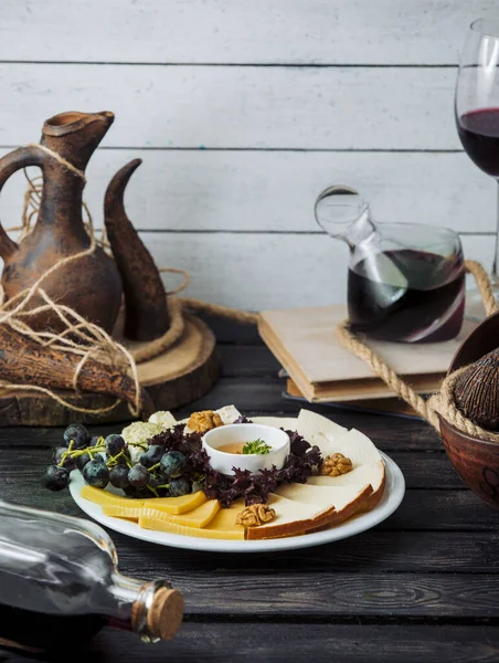 Osttallrik med cheddar, rökt, vit ost, valnöt, druva och honung — Stockfoto