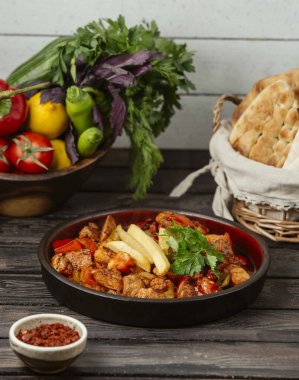 Kızarmış tavuk parçaları domates, biber ve patates kızartması ile pişirilir.