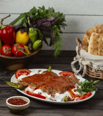 İskender kebabı domates sosuyla süslenmiş yoğurt.