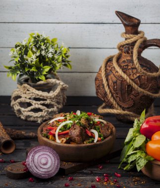 Domates, soğan dilimleri ve taze otlarla karıştırılmış kuzu kebap salatası.