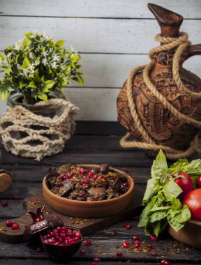 Nar ve kil tavada otlarla süslenmiş kuzu kebabı.