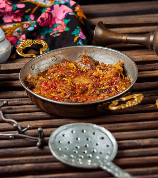 Смажені шматочки баранини з цибулею і помідорами в традиційній мідній сковороді — стокове фото