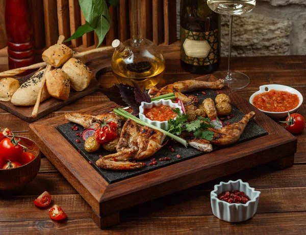 Grilled chicken pieces garnished with vegetables and herbs, served with aubergine salad Stock Photo