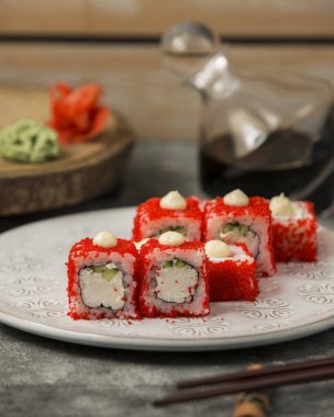 Yengeç çubuklu suşi ve kırmızı tobiko kaplı salatalık.