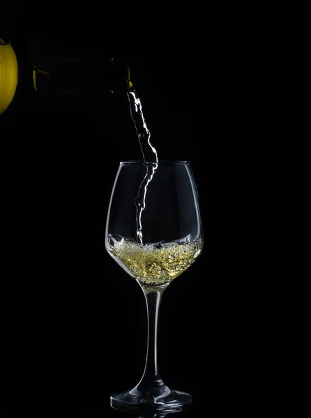 Vinho branco é derramado para baixo em copo de vinho em fundo preto — Fotografia de Stock