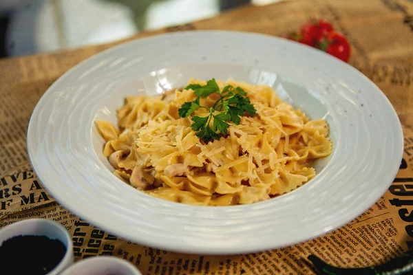 Primer plano de farfalle con champiñón y pollo adornado con parmesa y perejil —  Fotos de Stock