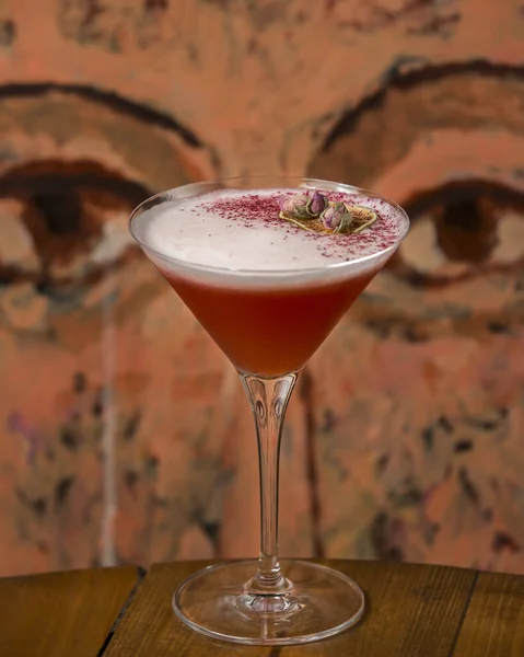 Пенный красный коктейль, украшенный сушеными бутонами роз — стоковое фото